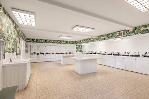 A spacious community laundry room with green floral wallpaper at The Aspens South Coast, California, 92504
