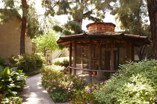 a bird aviary in a garden with plants and trees
