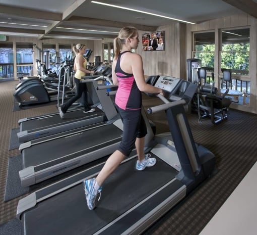 a woman running on a treadmill in a gym