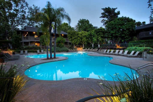 a swimming pool at night at an apartment community