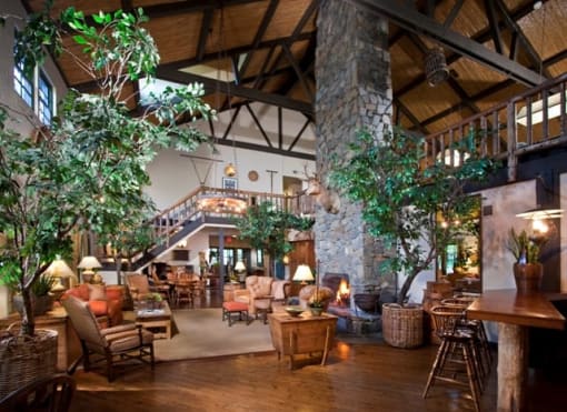 the lobby of a clubhouse with a large living room and a staircase