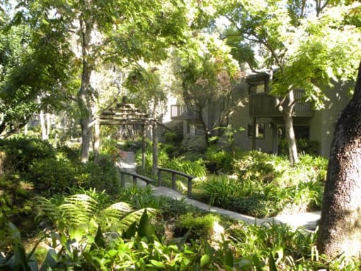 a apartment in the middle of a lush green garden