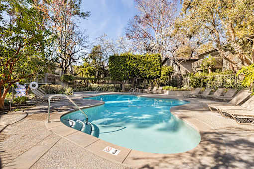 A small pool surrounded by trees and a fence at The Aspens South Coast, California, 92504