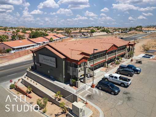 A building with the sign "Desert Mess" is surrounded by parked cars.