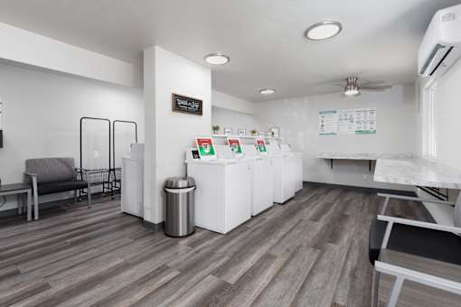 A white reception desk with a trash can and a sign on the wall.