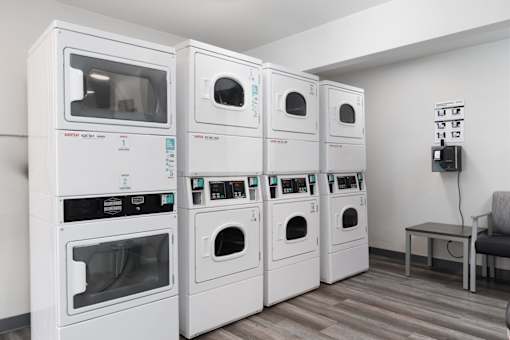 A row of white ovens are lined up in a room.