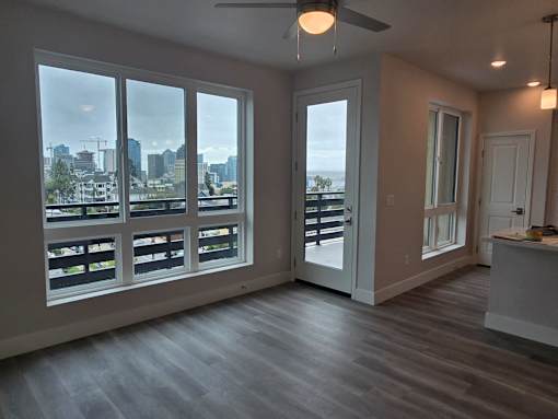 A room with a view of the city through large windows.