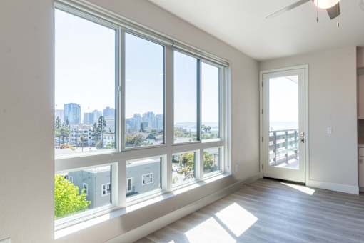 A room with a view of the city through large windows.