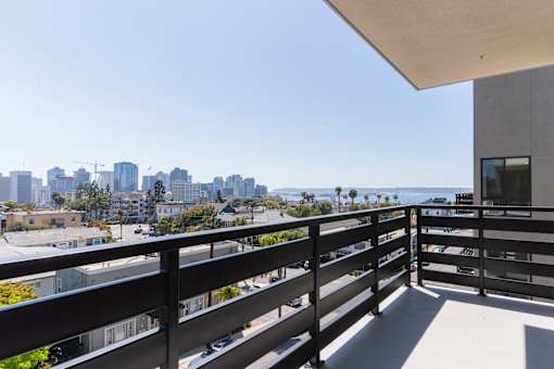A balcony with a railing overlooks a cityscape.