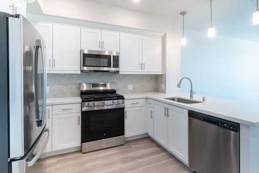 A modern kitchen with stainless steel appliances and white cabinets.
