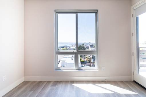 A room with a large window overlooking a street.