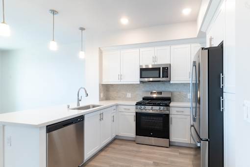 A modern kitchen with white cabinets and stainless steel appliances.