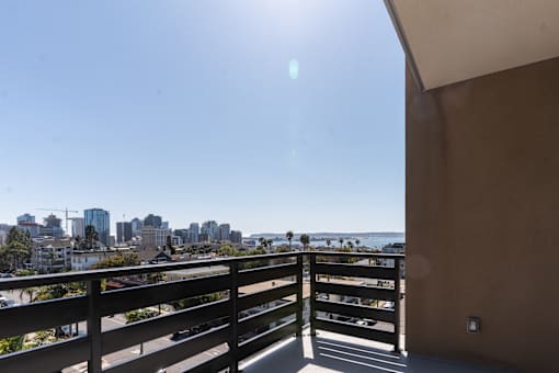 A balcony overlooks a cityscape on a sunny day.