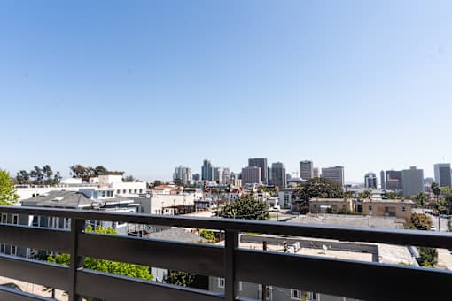 A cityscape is visible from a balcony.
