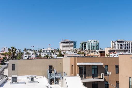 A modern building with a flat roof and a balcony is shown.
