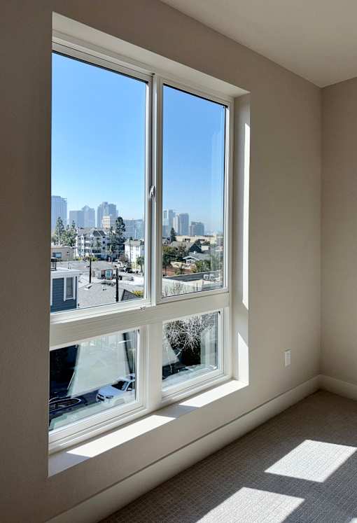 A room with a large window overlooking a cityscape.