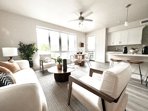 A living room with a white couch, a coffee table, and a ceiling fan.
