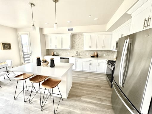 A kitchen with a white island and stainless steel appliances.