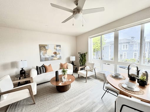 A living room with a white couch, a wooden coffee table, and a ceiling fan.