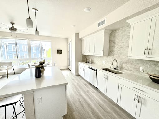 A kitchen with white cabinets and a large island.