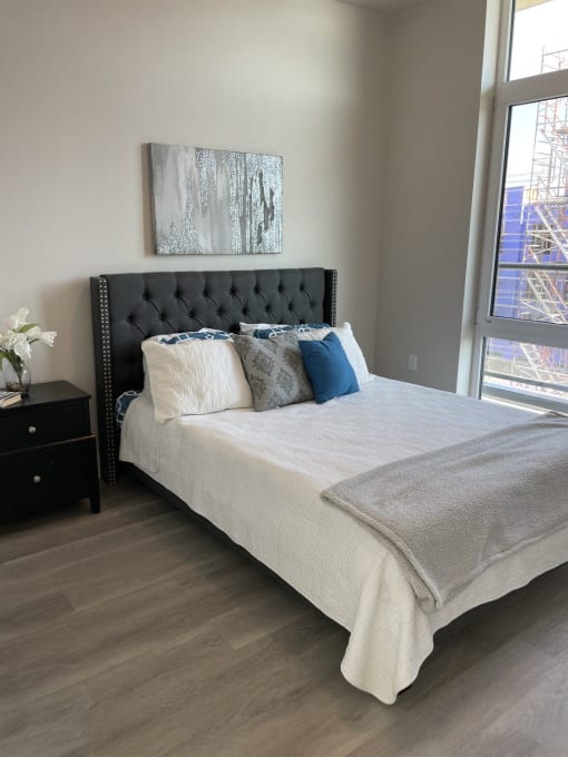 a bedroom with a bed and a large window