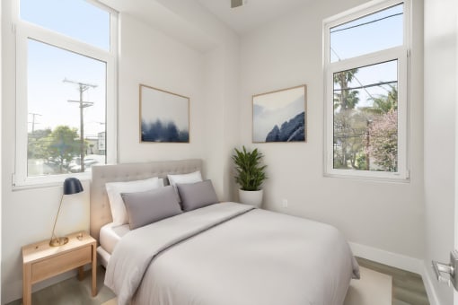 a bedroom with a large bed and two windows