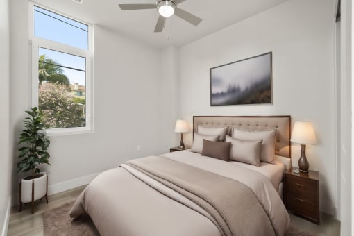 the guest bedroom of a modern home with a bed and a ceiling fan