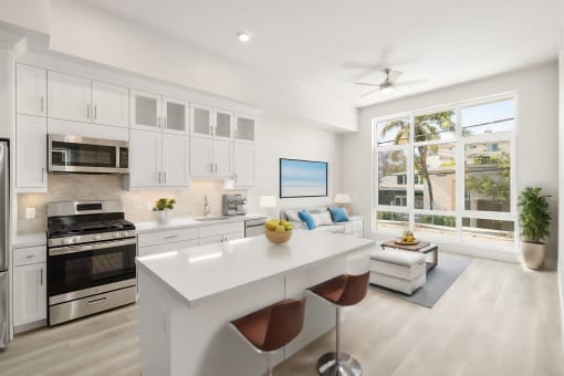 an open kitchen and living room with white cabinets and stainless steel appliances