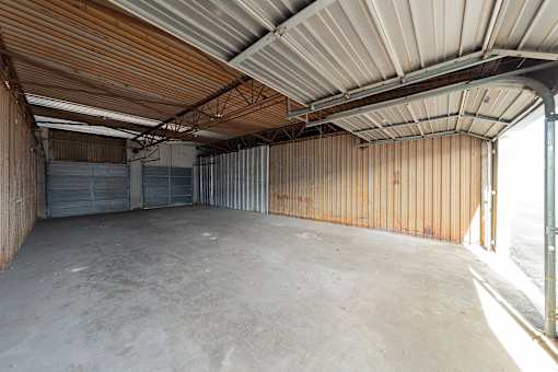 A large, empty storage unit with a wooden ceiling and metal walls.