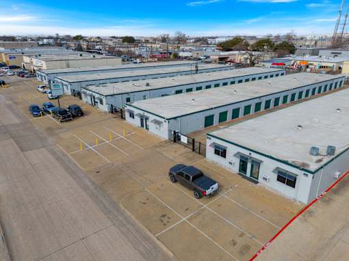 A parking lot with several cars and a building in the background.