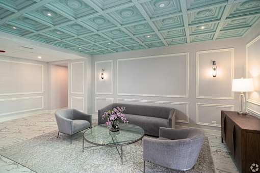 a living room with gray couches and a glass coffee table