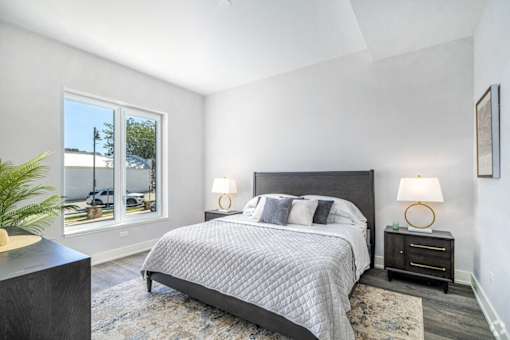 a bedroom with a bed and two windows