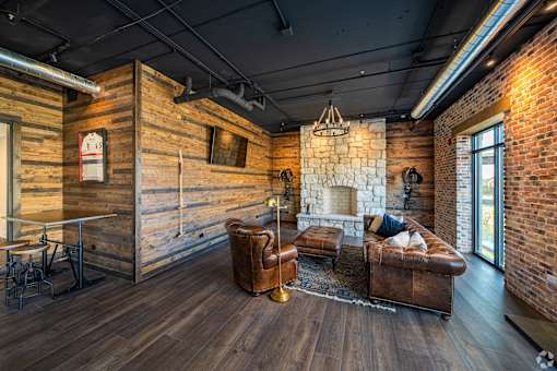 a living room with leather furniture and a stone fireplace