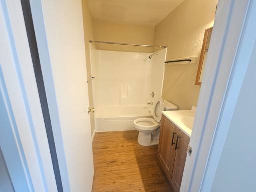 A bathroom with a toilet, sink and shower.