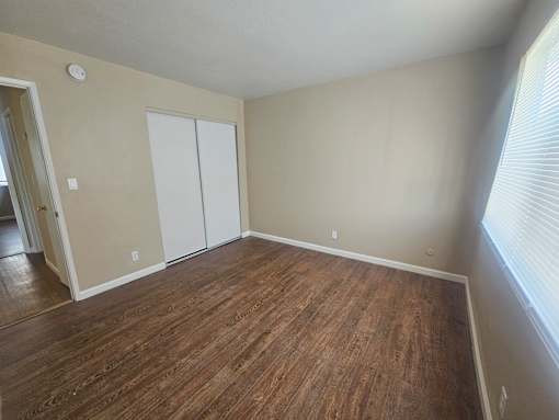 A room with a wood floor and a white closet.