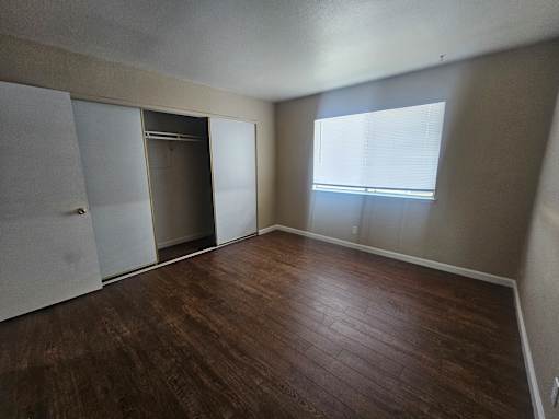 Empty room with a brown floor and white walls.
