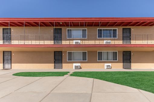 A building with a red roof and a green lawn in front.