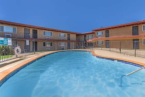 A swimming pool in front of apartment buildings.