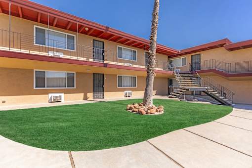 A building with a red roof and a palm tree in front.