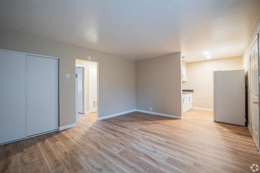 A room with wooden flooring and white walls.