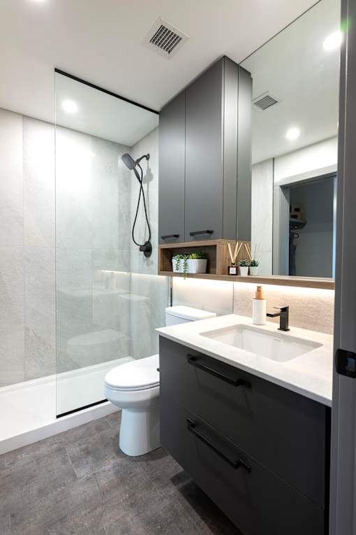 A modern bathroom with a white sink and a walk-in shower.