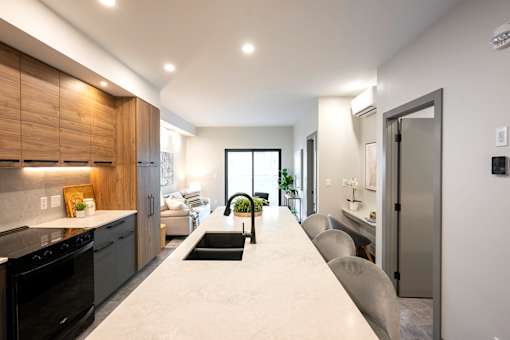 A modern kitchen with a black oven and a long white countertop.