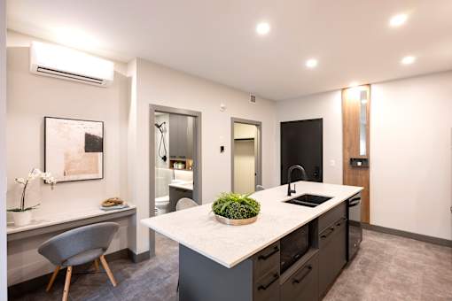 A modern kitchen with a large island and a dining area.