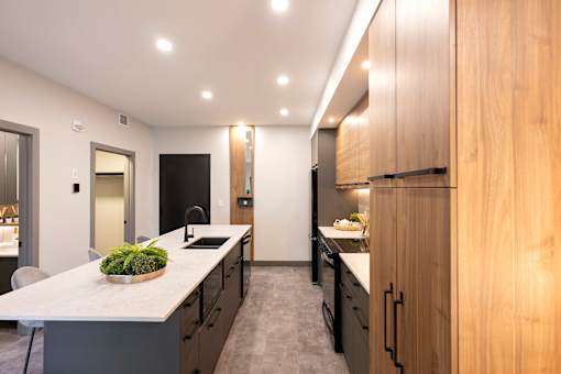 A modern kitchen with a large island and wooden cabinets.