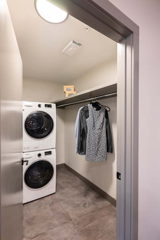 A laundry room with a washer and dryer stacked on top of each other.