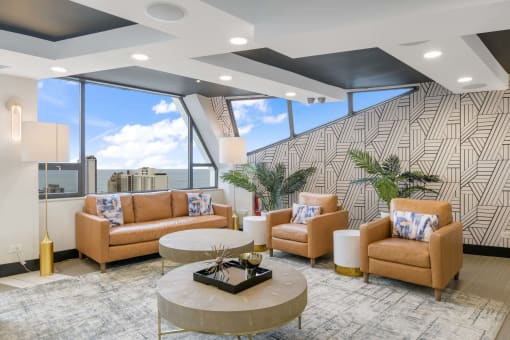 a lobby with couches and a table in front of a window