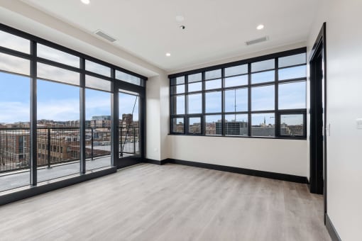 the living room has windows and a view of the city