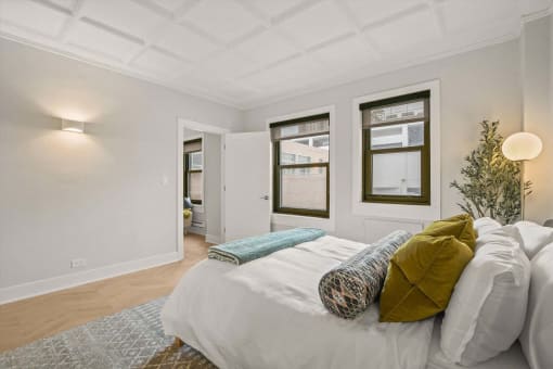 a bedroom with a bed and three windows