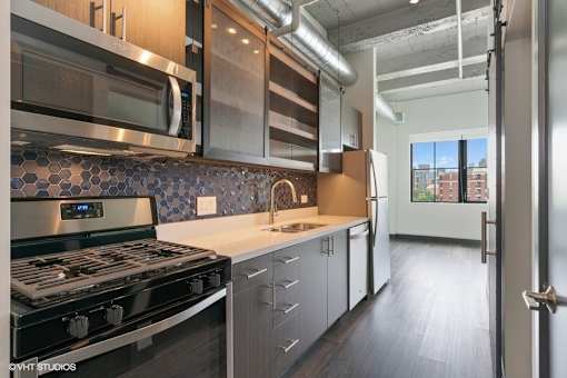 a kitchen with a stove and a sink and a microwave