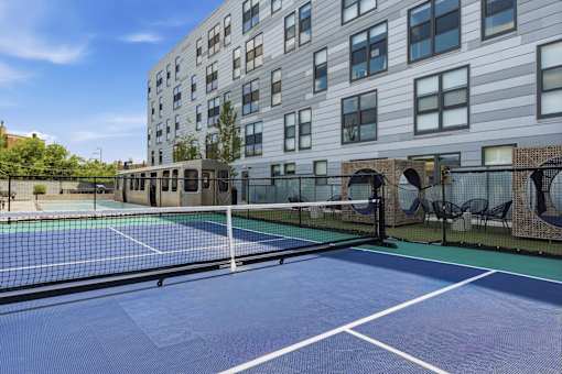 A tennis court is located on the roof of a building.